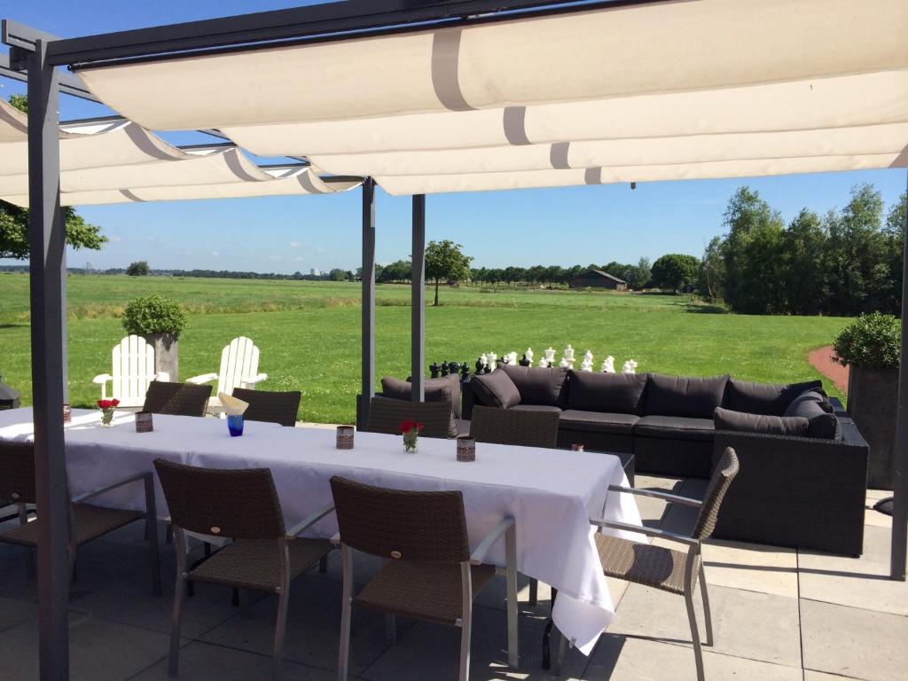 una mesa y sillas bajo una sombrilla en un patio en The Waverly House, en Ouderkerk aan de Amstel