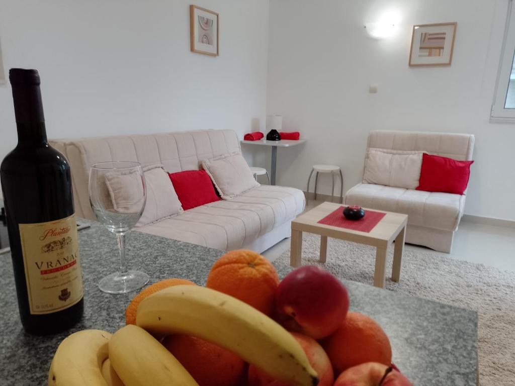 a living room with a bottle of wine and fruit on a table at Splendid studio apartment in Bečići