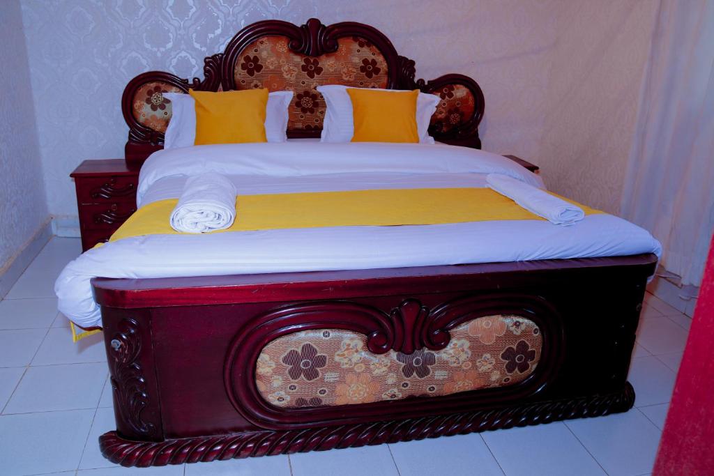 a large bed with a wooden headboard in a room at Dolly Apartments in Nairobi