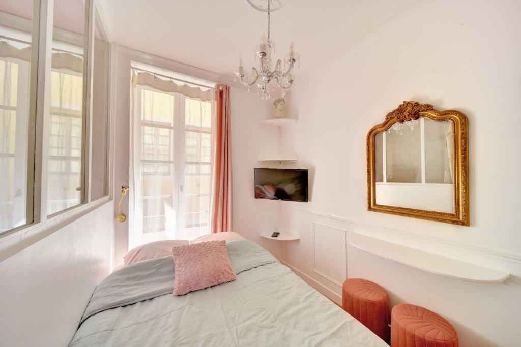 - une chambre avec un lit et un miroir dans l'établissement Les Petits Boudoirs de Savoie, à Chambéry