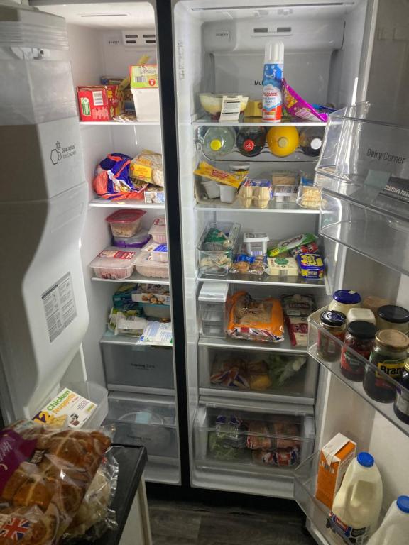 um frigorífico aberto com a sua porta aberta e comida no interior em Danny holiday home em Blackpool