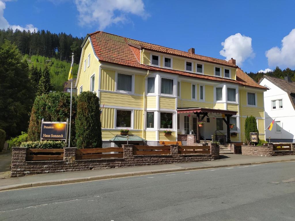 une maison jaune sur le côté de la rue dans l'établissement Pension Haus Sonneck, à Wildemann