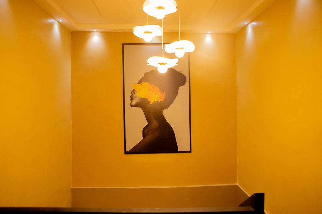 a painting of a woman on a yellow wall at Urban Condos in Accra