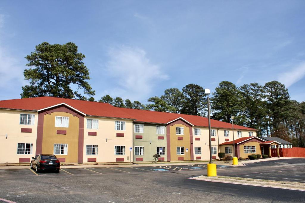 un aparcamiento vacío frente a un edificio en HomeTown Inn & Suites en Longview