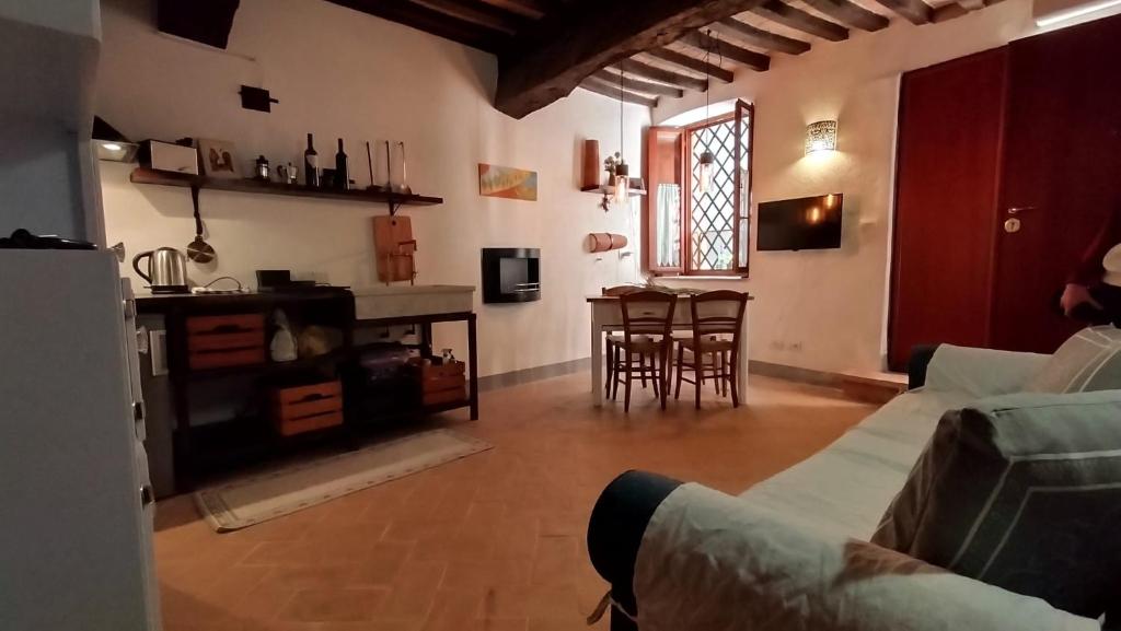 sala de estar con sofá y mesa con sillas en Casa Vacanze Carducci en San Casciano dei Bagni