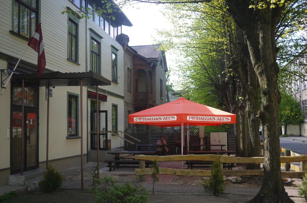 um guarda-chuva vermelho sentado ao lado de uma mesa na rua em Easy Stay Apartments em Riga