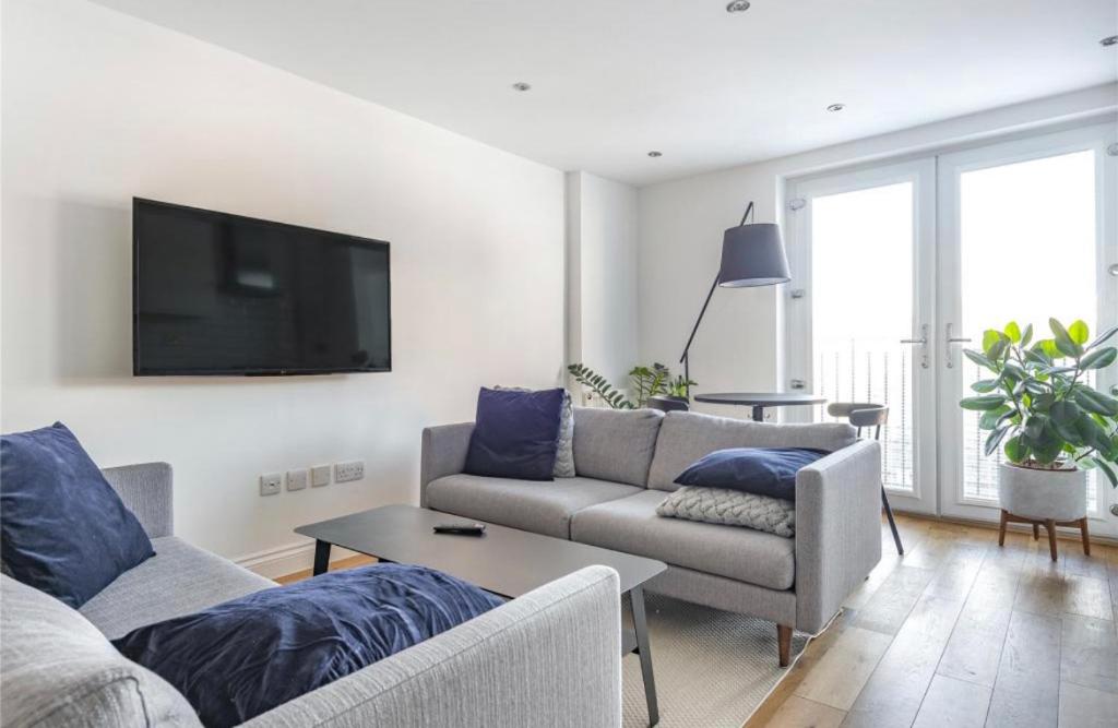 a living room with two couches and a flat screen tv at No.1 Universal House - Double Bedroom Apartment in Bromley
