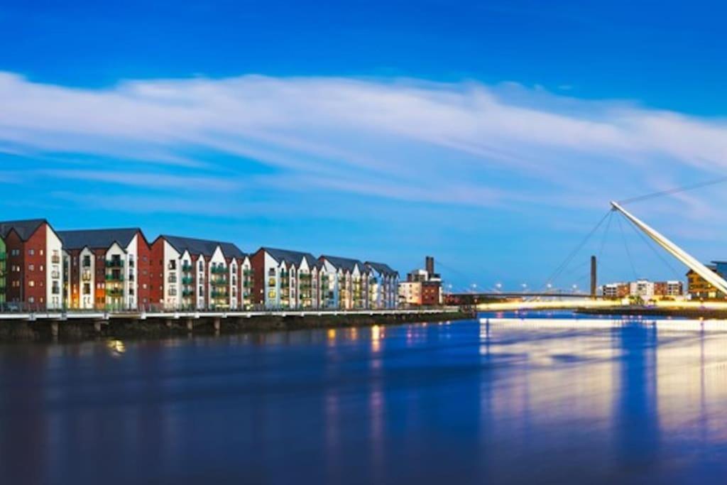 un puente sobre un cuerpo de agua con edificios en Luxury Riverfront Apartment, en Newport