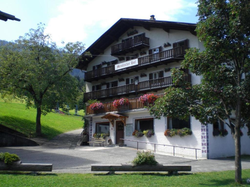 ein großes weißes Gebäude mit Balkonen und Blumen in der Unterkunft Ferienwohnung Rosengarten am Manötscherhof in Karneid