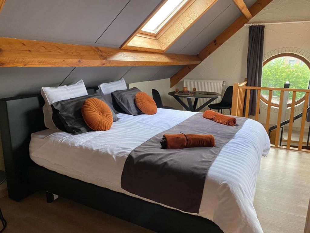 um quarto com uma cama grande com almofadas em Au Refuge du Bois em Walhain-Saint-Paul