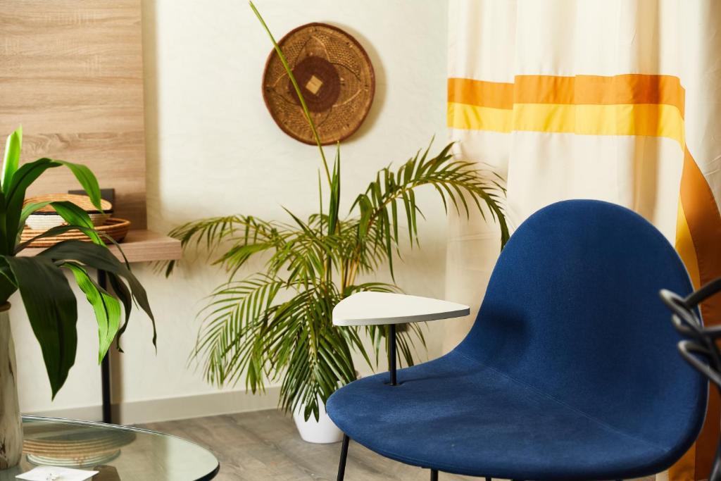 a blue chair in a room with plants at ONOMO Hotel Abidjan in Abidjan
