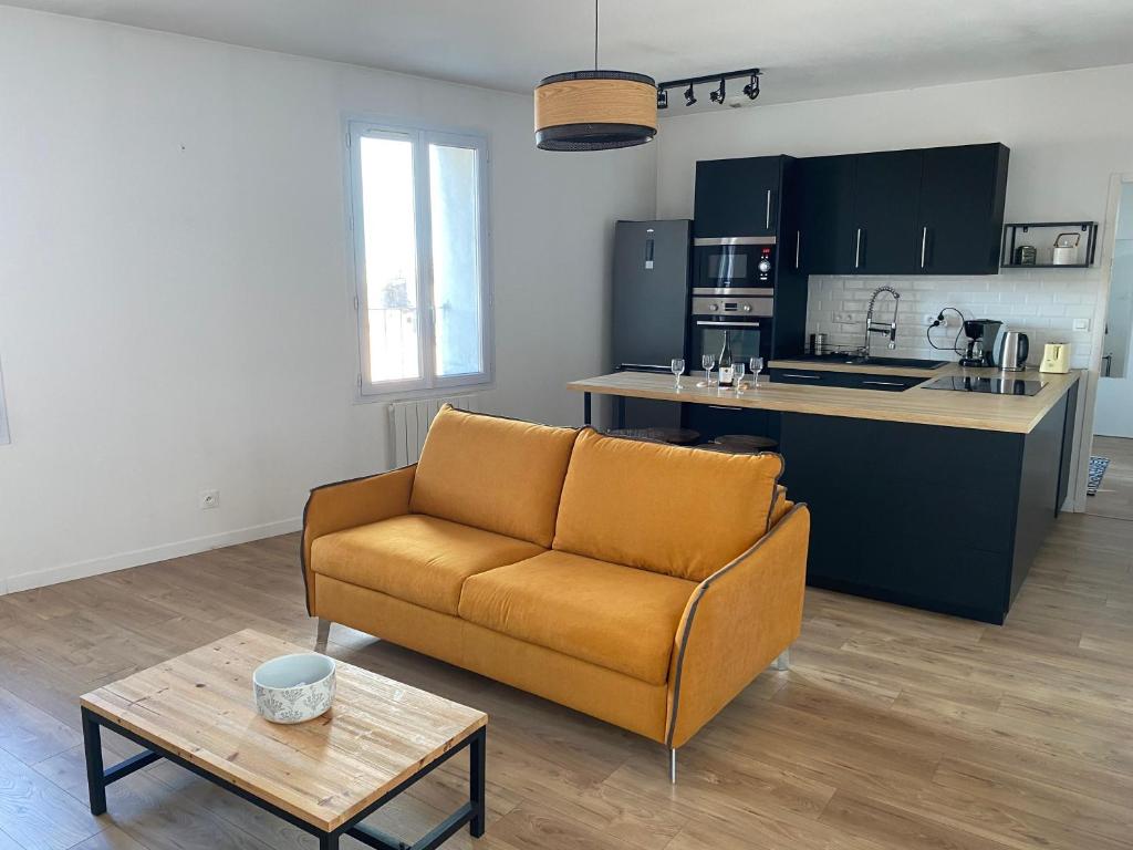 un salon avec un canapé et une cuisine dans l'établissement Joli F3 SETE à la Caraussanne, à Sète