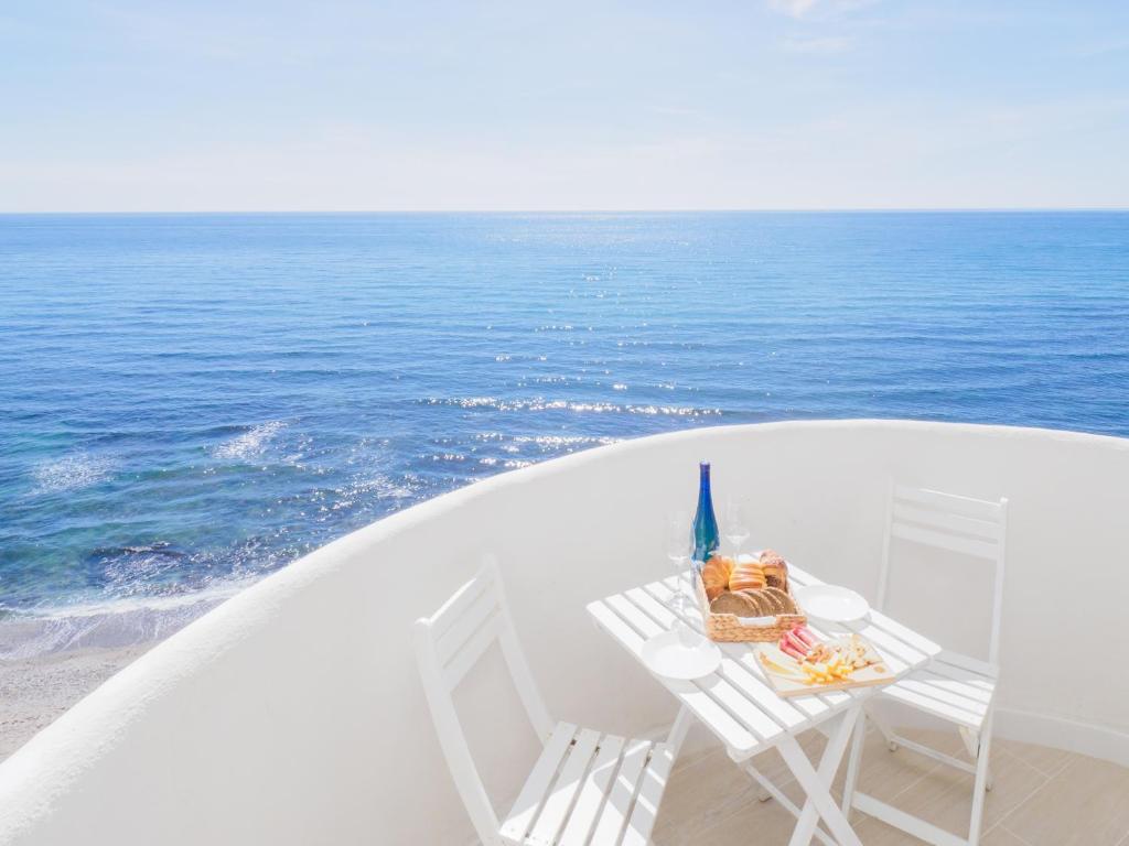 een tafel en 2 stoelen op een balkon met uitzicht op de oceaan bij Apartment on Beach Mijas 2 in Sitio de Calahonda