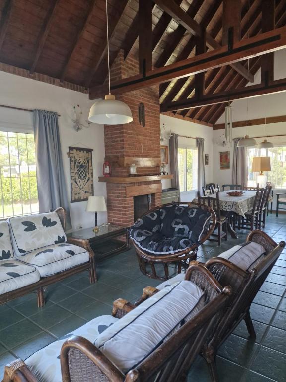 a living room with chairs and a fireplace at Dunas Chalet y Apartamento in Pinamar