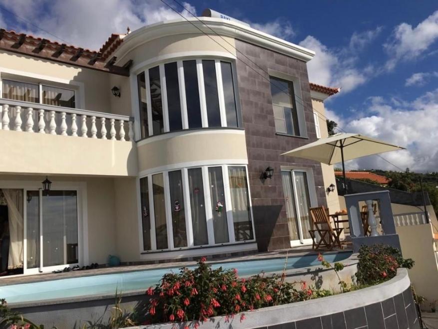 uma casa com uma piscina em frente em Slice of ponta do sol Room 1 em Ponta do Sol