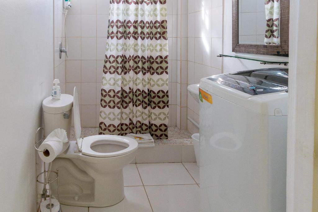 e bagno con servizi igienici e tenda per la doccia. di Caribbean Dream Vacation Property CD1 a Gros Islet