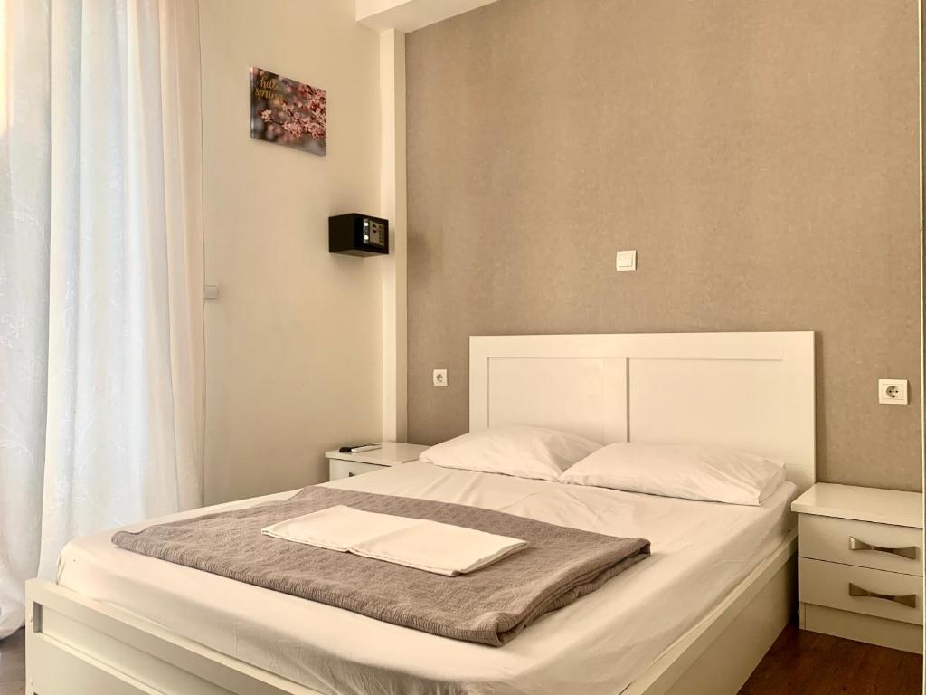 1 dormitorio con 1 cama blanca grande con sábanas blancas en City Center Athenes rooms en Athens