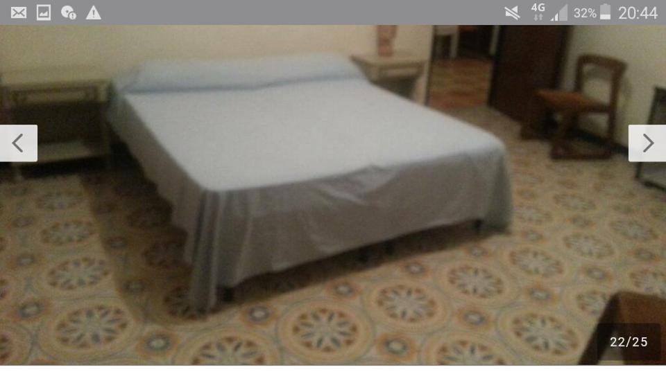 a white bed in a room with two arrows at Tropea center room in Tropea