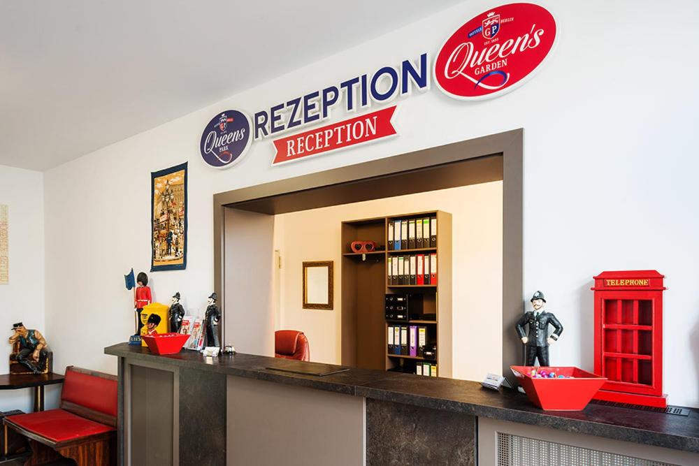 una biblioteca con una señal roja y una cabina telefónica roja en Queens Park Hotel, en Berlín