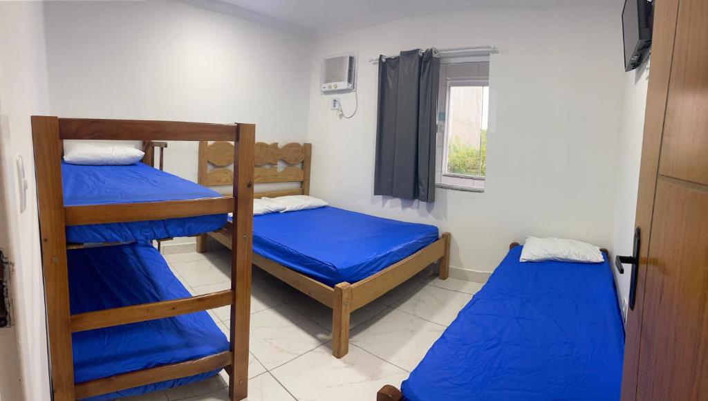 a room with two bunk beds and a window at SUITEs E FLATs MONTE ALTO ARRAIAL DO CABO in Arraial do Cabo