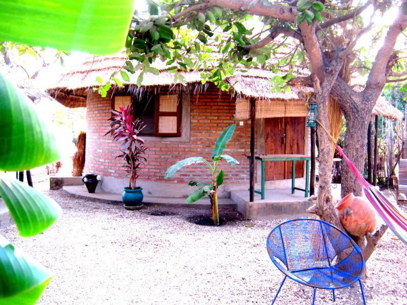 una pequeña casa con una silla azul delante en Evergreen Eco Lodge Retreat, en Tujering