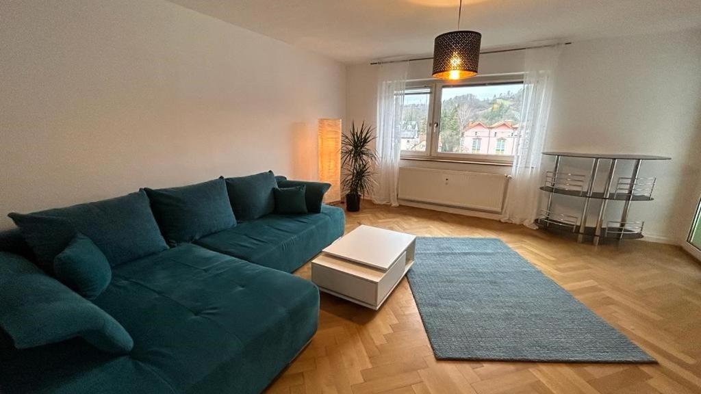 sala de estar con sofá verde y alfombra en Paradiesisch Wohnen Bad Schwalbach, en Bad Schwalbach