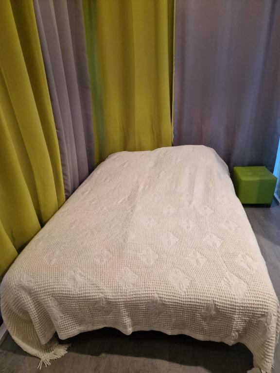 a small bed in a room with colorful curtains at LES CERISIERS 1 in Nogaro