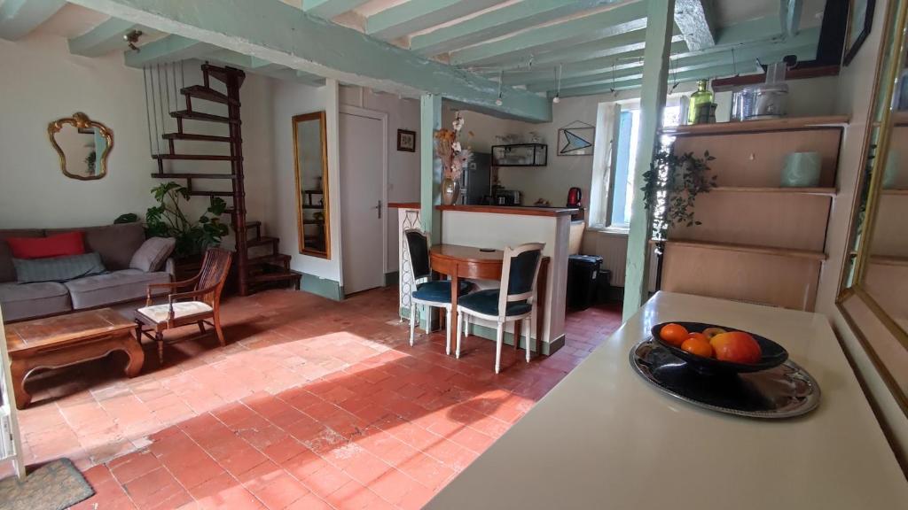 a kitchen and living room with a bowl of fruit on a counter at La Chaumière de Chaumont in Chaumont-sur-Loire