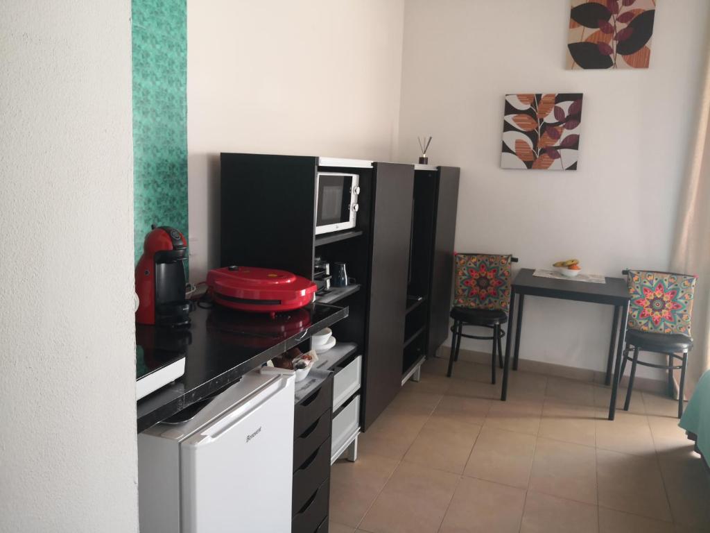 eine Küche mit einer schwarzen Theke und einer Mikrowelle in der Unterkunft El Limonero in Tías
