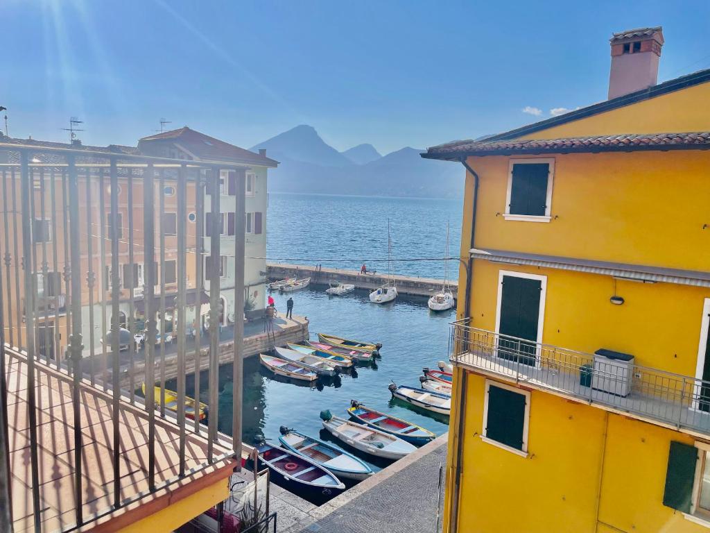 a group of boats in the water between two buildings at Cà Irene - Cà Battistoni in Brenzone sul Garda