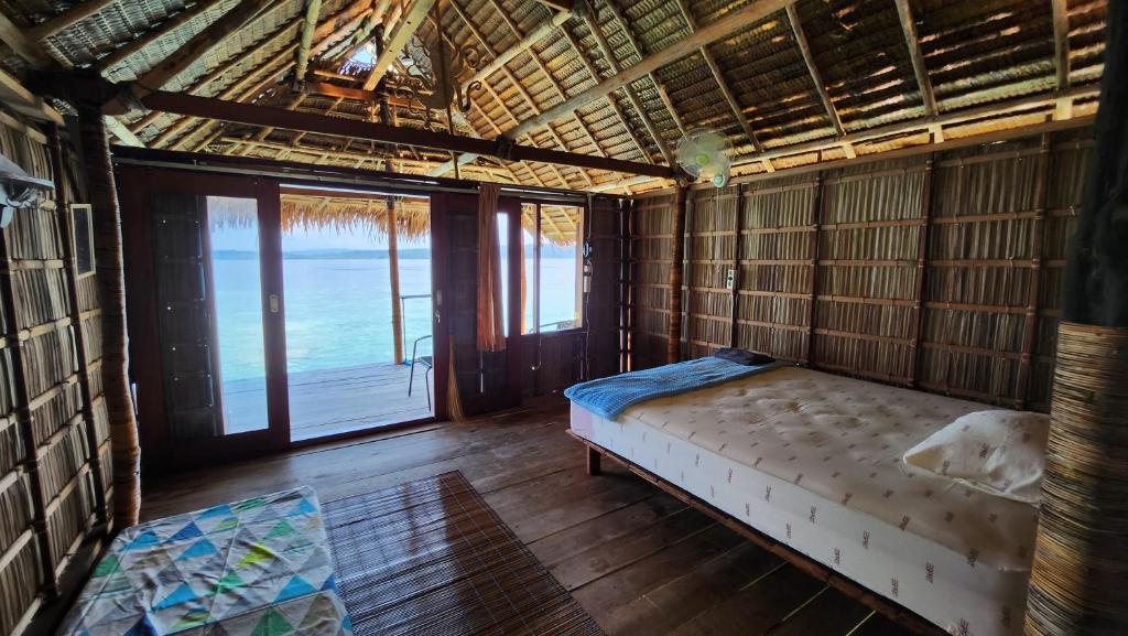 a bed in a room with a view of the ocean at Terimakasih homestay in Pulau Mansuar