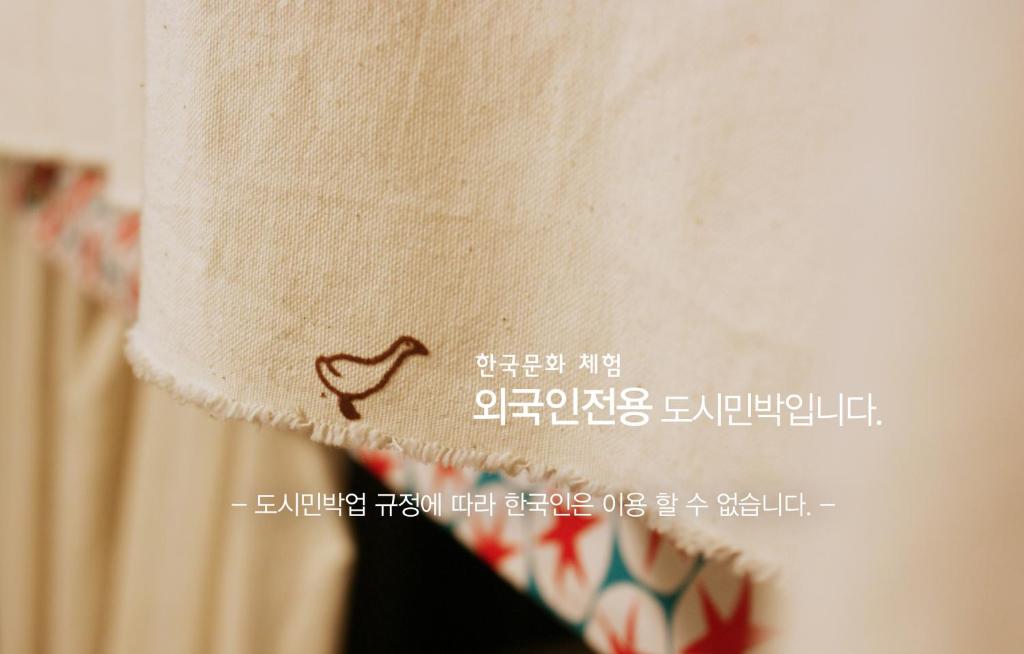 a close up of a persons neck with a heart embroidered at Aark House in Gangneung