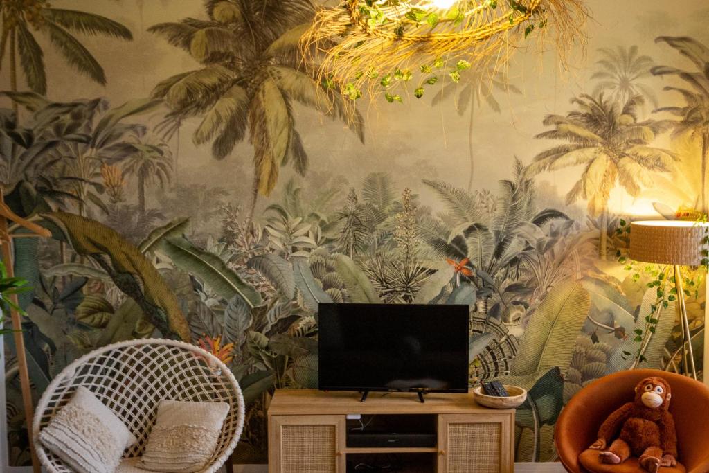 salon z muralem palmowym w obiekcie SUITE JUNGLE - JARDIN, NETFLIX et PARKING - Le Manoir aux Pommes w mieście Orbec-en-Auge