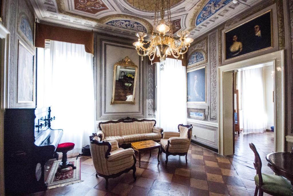 sala de estar con sofá, sillas y lámpara de araña en Hotel Europa, en Ferrara