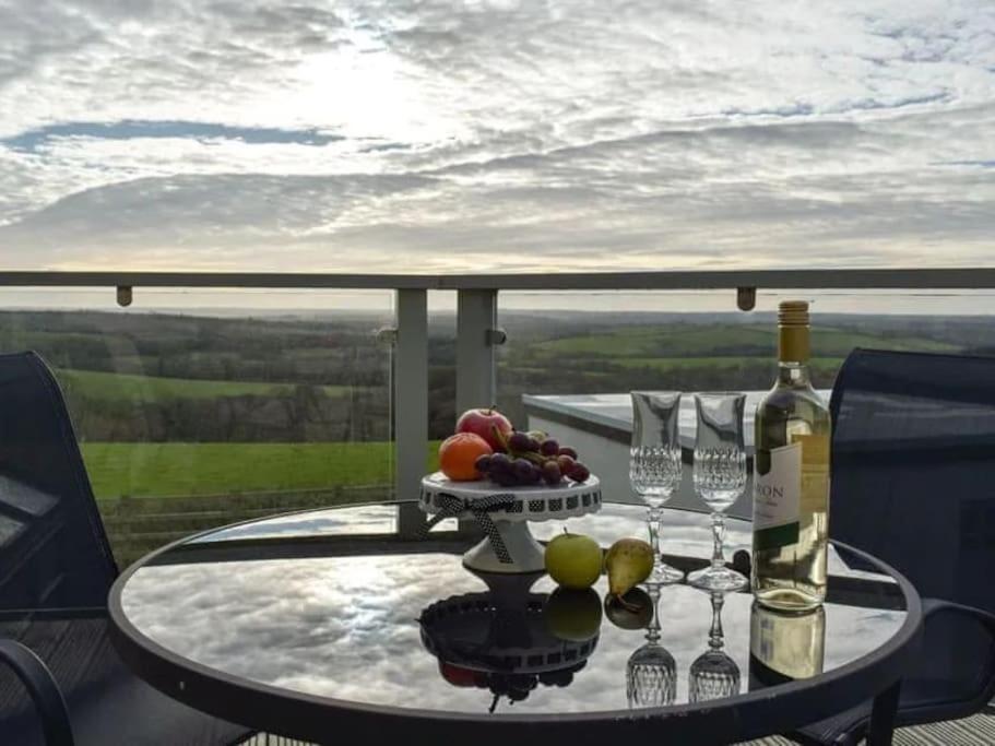 a table with a plate of fruit and wine glasses at Meadow View in Haverfordwest