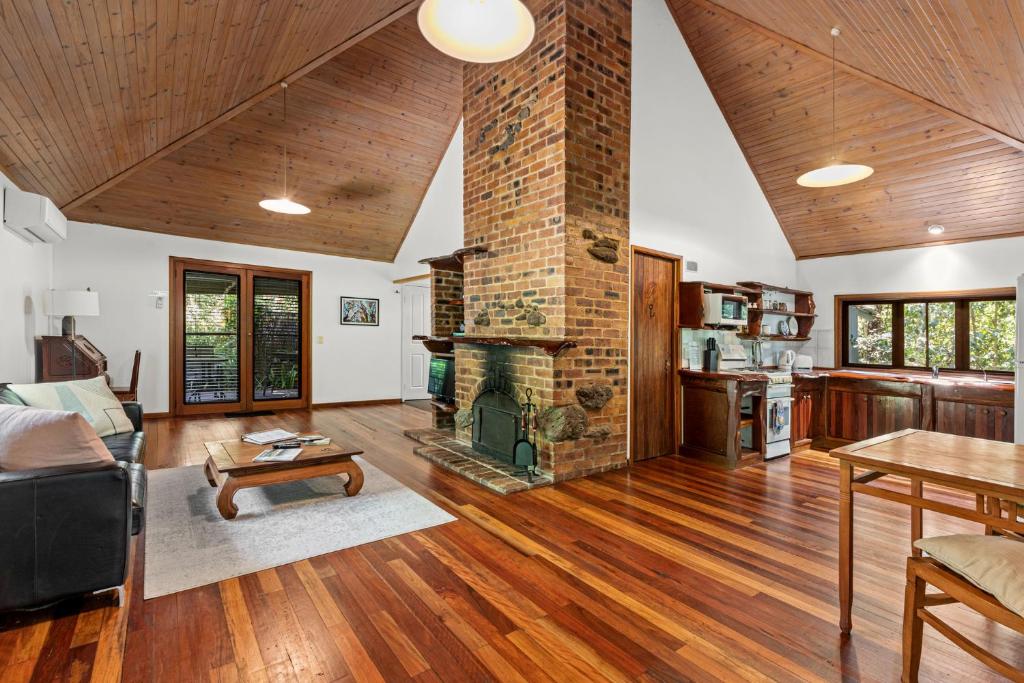 a living room with a fireplace and a table at Hunchy Hideaway in Montville