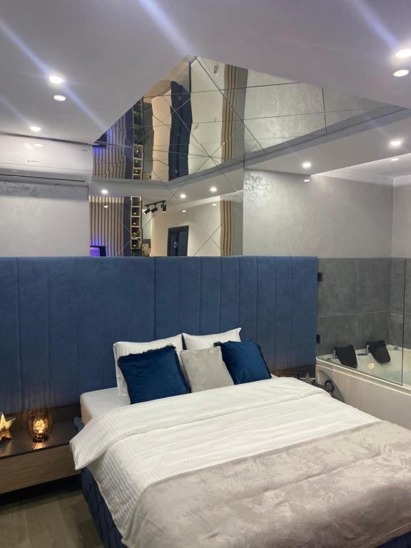 um quarto com uma cama grande e uma parede azul em SpaNish apartman em Niš