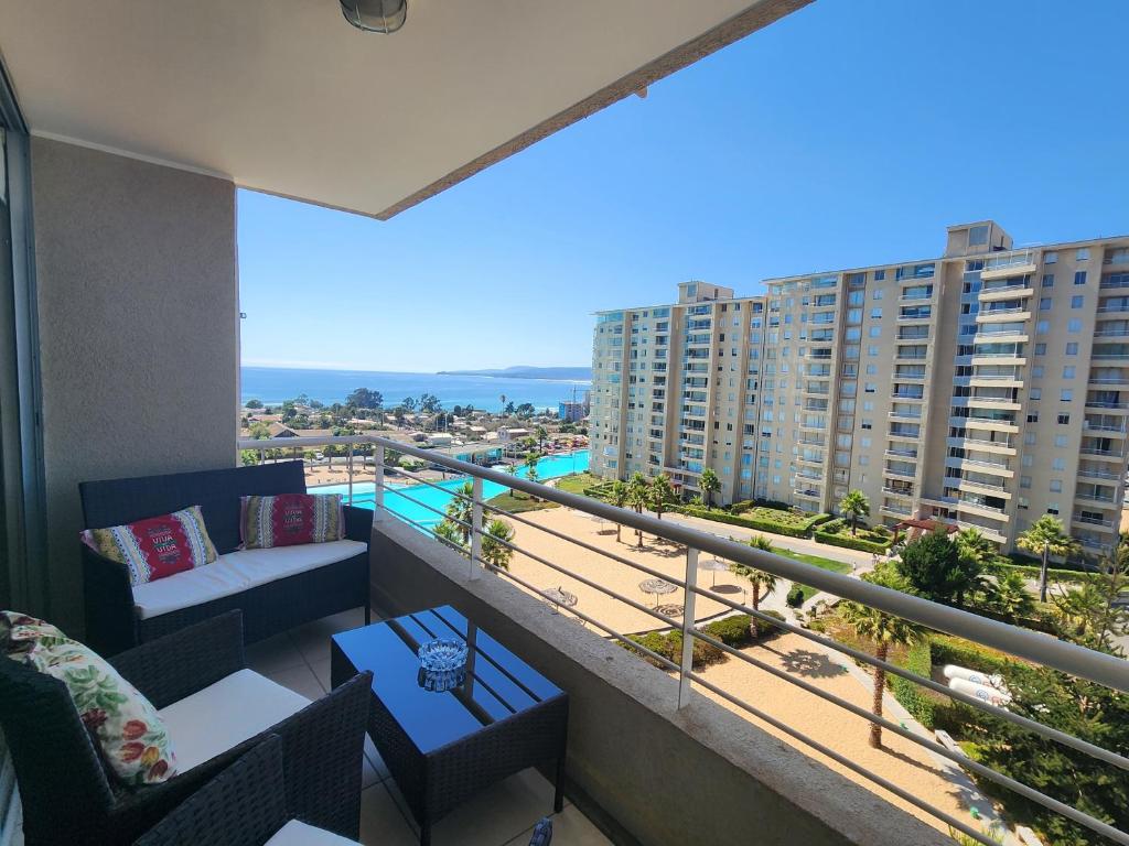 een balkon met uitzicht op het strand en de gebouwen bij Departamento Laguna Vista in Algarrobo