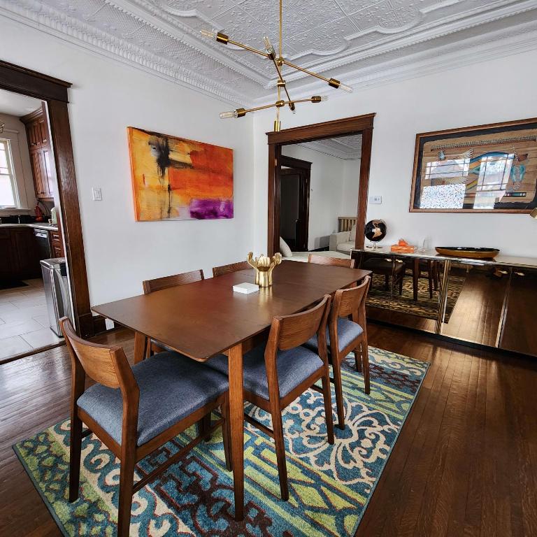 uma sala de jantar com uma mesa de madeira e cadeiras em The Pandora Century Home em Kitchener