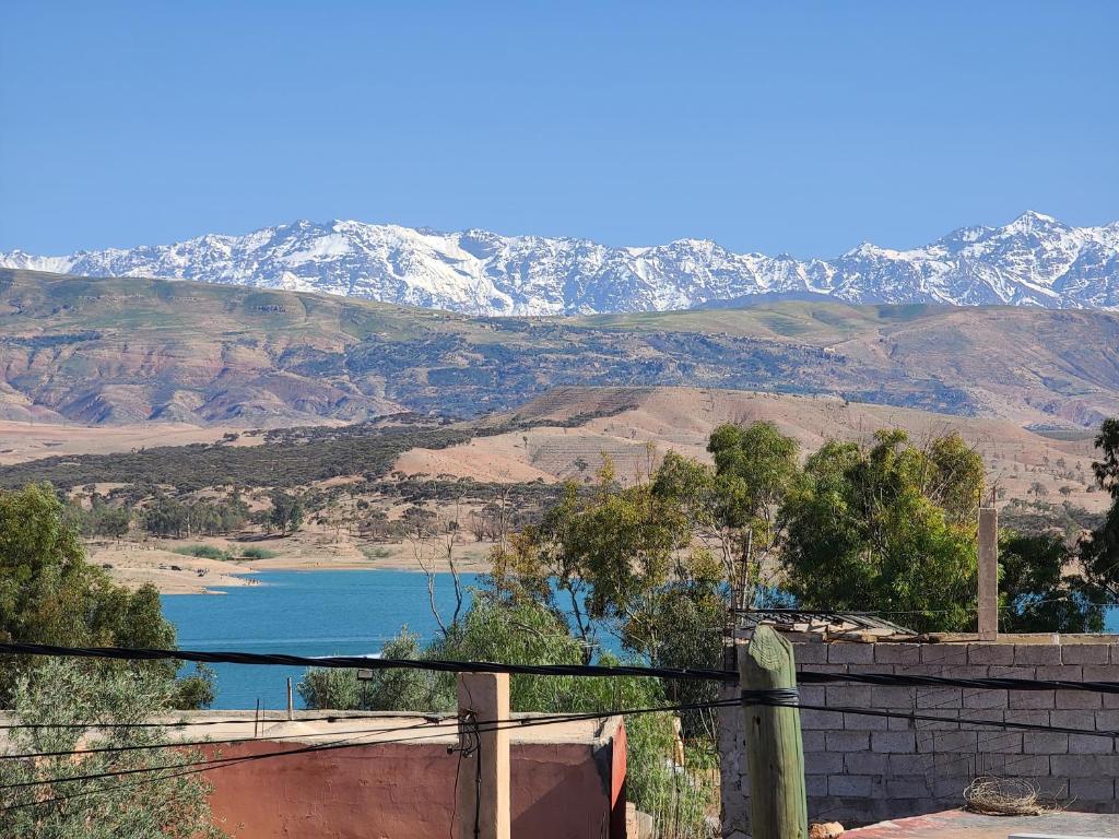 a view of a body of water with snow covered mountains at Dar de l'Atlas in Lalla Takerkoust