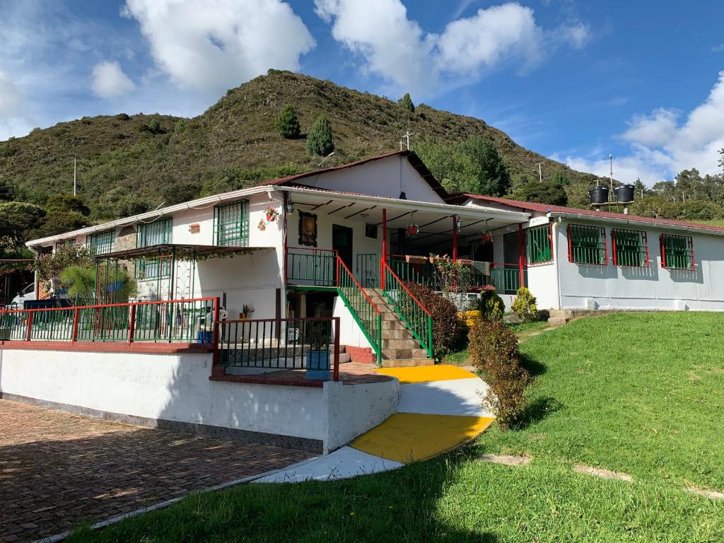 a house with a mountain in the background at Hotel Cerro Fuerte in Sopó