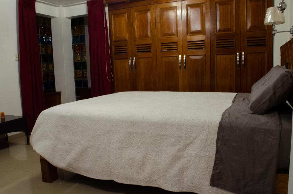1 dormitorio con 1 cama con armarios de madera en Irene's House, en Lima