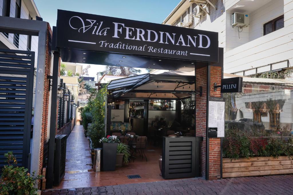 un restaurant avec un panneau indiquant la ville ferdinand et un restaurant traditionnel dans l'établissement Vila Ferdinand Modern Rooms In Tirana's Center, à Tirana