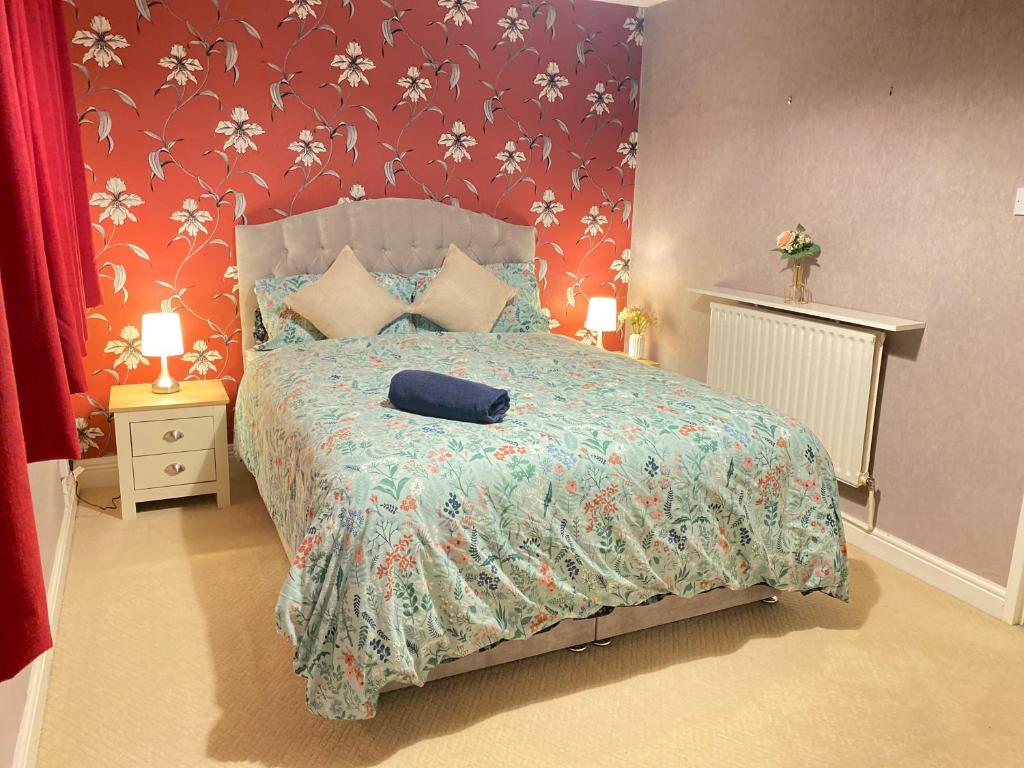 een slaapkamer met een bed met een blauwe tas erop bij A Perfect Two Bedroom House for a Family Stay in Havering atte Bower