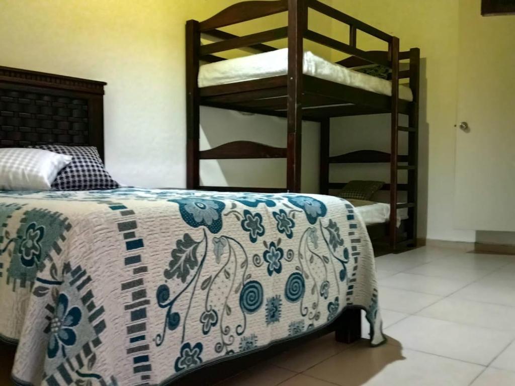 a bedroom with two bunk beds and a bed with a blanket at Hostal la nube in San Cristóbal de Las Casas