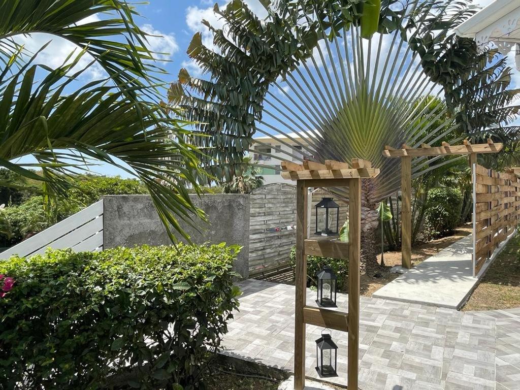 a garden with a wooden structure with two lights at Kaza Mango in Sainte-Luce