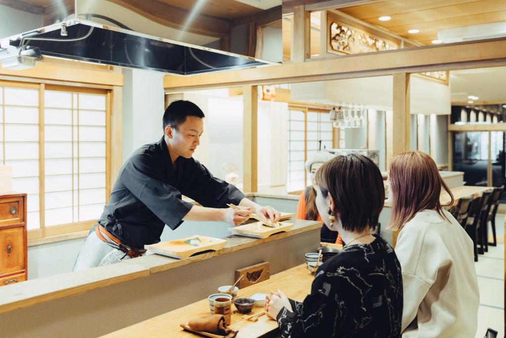 Un uomo che prepara il cibo al bancone di un ristorante di Mitsubikiya a Matsumoto