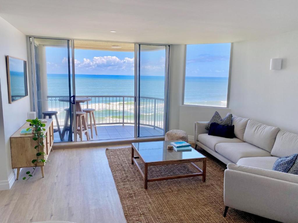 a living room with a couch and a view of the ocean at Monterey Lodge - Unit 18, 27 Warne Terrace, Kings Beach Caloundra in Caloundra