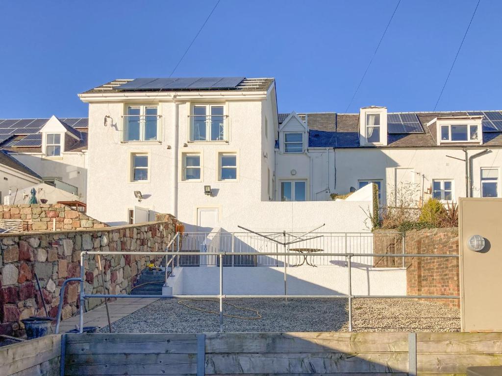 a white building with stairs in front of it at Ardstinchar Mews in Ballantrae