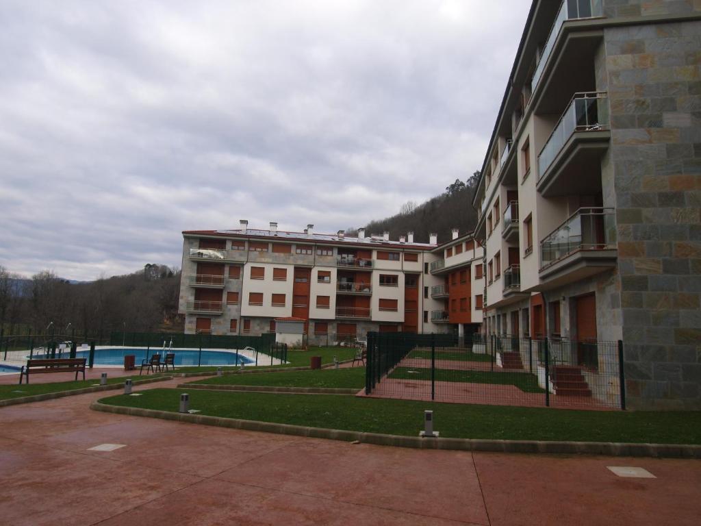 an apartment building with a swimming pool in front of it at Apartamento El Abuelo in Cangas de Onís